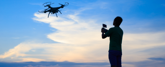 man flying drone against blue sky